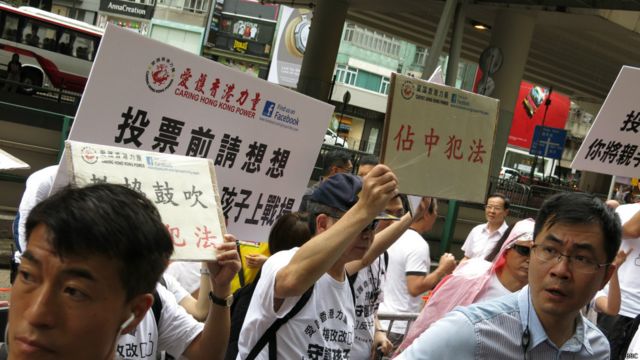 親北京示威者在「佔領中環」投票銅鑼灣教協票站外喊口號反對是次投票（BBC中文網圖片22/6/2014）