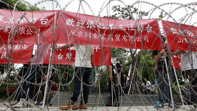 有台商團體手持「歡迎張志軍主任訪台」紅布條，在街道的另一旁與抗議人士對峙。「