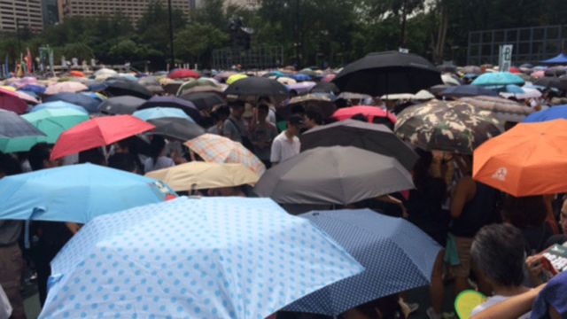 星期二上午，香港曾下大雨。下午天氣悶熱，不少參加遊行的市民都帶了雨傘，防雨防曬