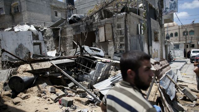 哈馬斯成員站在廢墟前