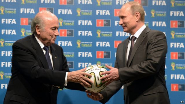 Мяч в руках Владимира Путина (справа) - символ проведения ЧМ-2018 в России