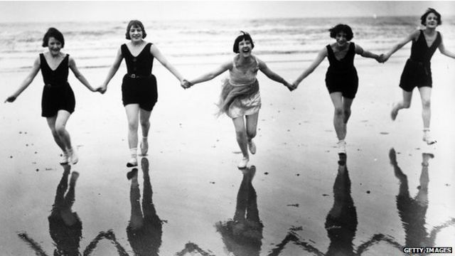 En una foto antigua, jóvenes ríen en una playa