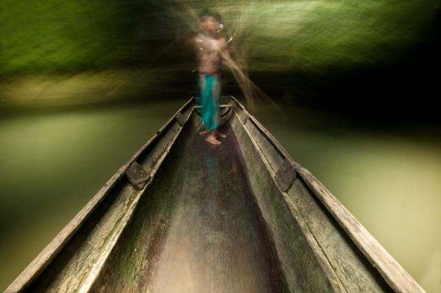 Un indígena emberá atraviesa el río Mogué.