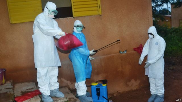 Médicos com roupa de proteção para tratar o ebola / Crédito: AFP