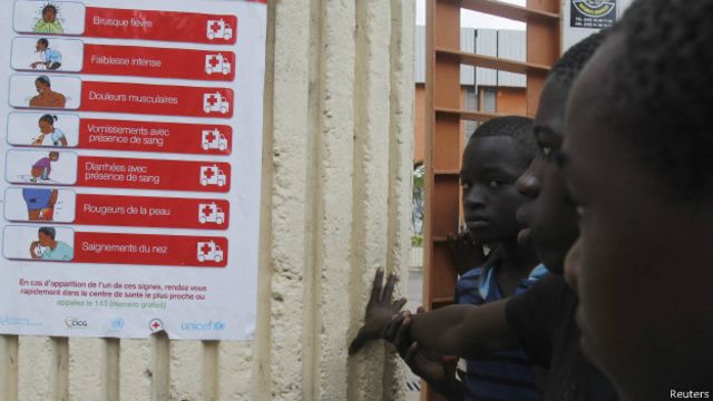 Niños miran cartel con información sobre prevención del ébola en Sierra Leona