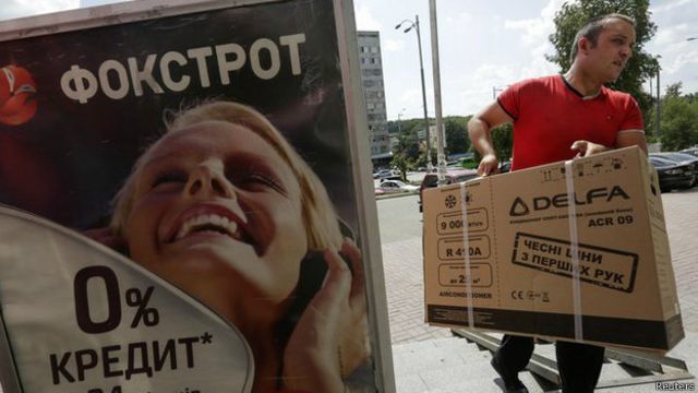 Hombre con caja de producto electrónico en Kiev (foto de archivo)