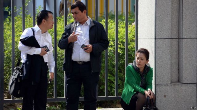 辩护律师李方平与伊力哈木的兄弟交谈,旁边是伊力哈木妻子。