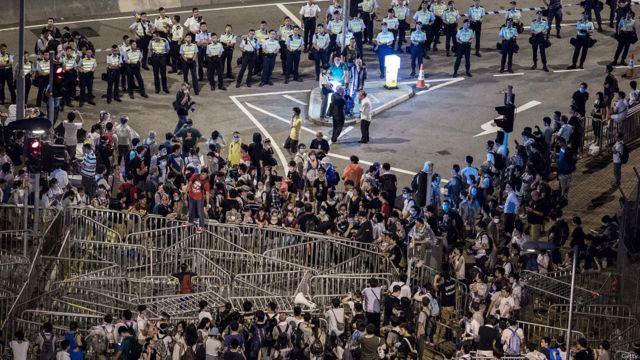 在香港政府總部封鎖線外，有大批學生和示威者留守，與警方對峙。