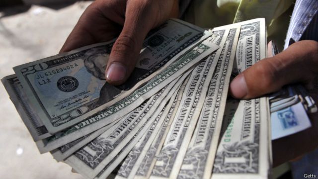 Человек держит в руках доллары