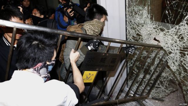 蒙面示威者用鐵馬砸破香港立法會大樓的玻璃門（19/11/2014）