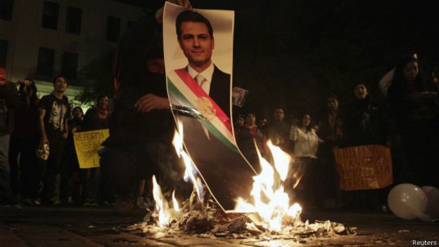 Manifestantes queman una foto del presidente Enrique Peña Nieto