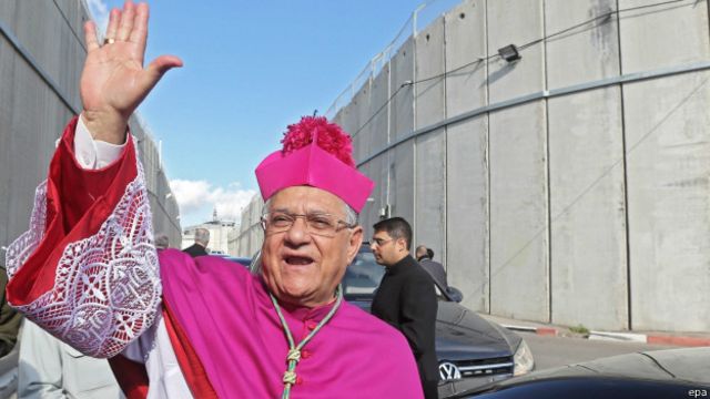 特瓦爾宗主教在通過以色列隔離牆時向記者揮手（24/12/2014）