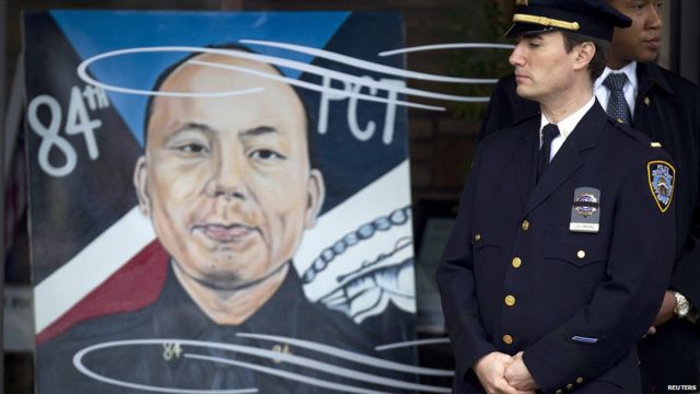 一名紐約市警察局警員在劉文健遺像前站立（4/1/2015）