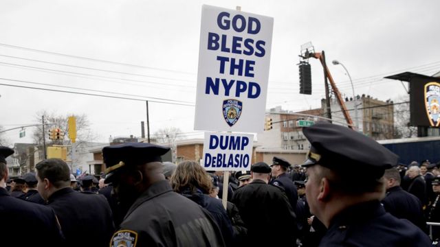 警員在劉文健葬禮上舉起「天佑紐約市警察局，拋棄白思豪」標語（4/1/2015）