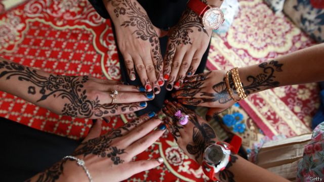 Jóvenes yemeníes muestran sus manos decorados con la tradicional henna