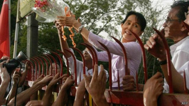 Aung San Suu Kyi berdiri dari balik gerbang rumahnya saat dibebaskan pada 2010 lalu.