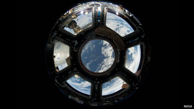 A foto mostra a vista da Terra do interior da Estação Espacial Internacional. No canto superior esquerdo, pode-se ver a cápsula russa Soyuz. Já no canto inferior direito, um painel de energia solar se destaca. (Crédito: NASA)