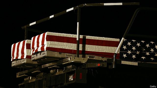Погибших американских солдат перевозят на родину в гробах, покрытых национальными флагами
