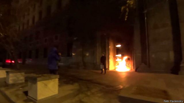 Скриншот с видео: Павленский на фоне горящей двери