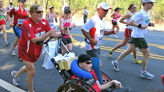 Dick Hoyt en una carrera empujando la silla de ruedas de su hijo Rick en 2012