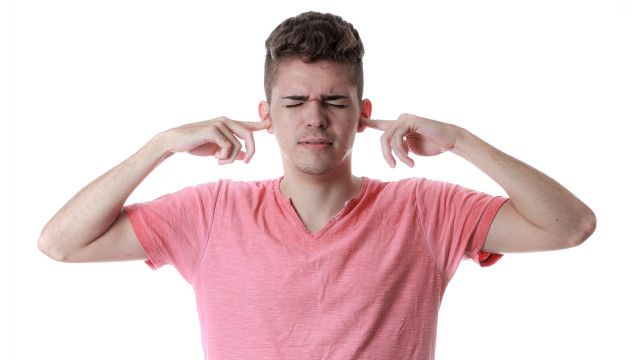Una persona tapándose los oídos