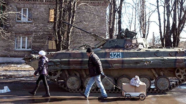 цивільні люди біля танку