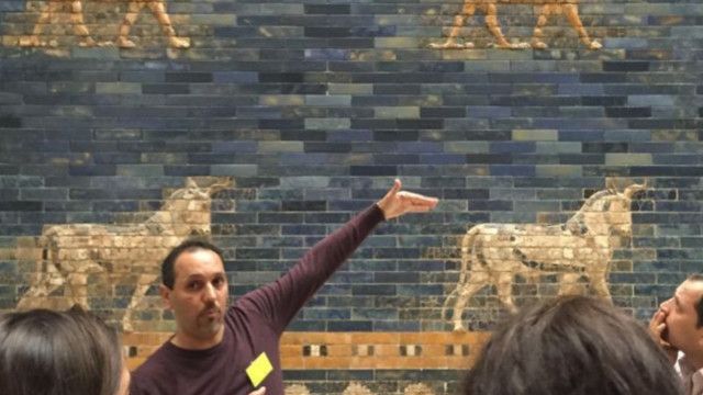 بشار من سوريا يشرح للزائرين للمتحف بوابة عشتار التاريخية.