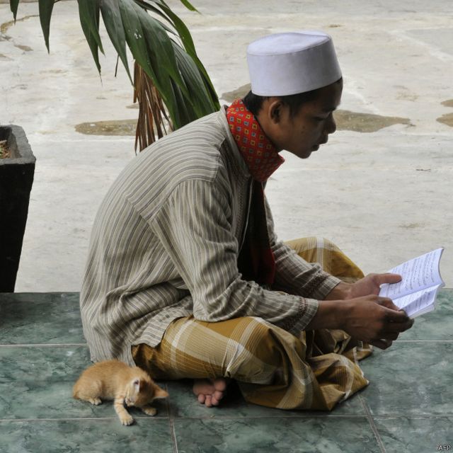 Seorang muslim tengah membaca sebuah kitab di komplek makam Habib Hasan bin Muhammad al Hadad di Jakarta, 16 April 2010. Praktik ziarah kubur ditolak oleh gerakan Wahabi karena dianggap menyalahi ajaran Islam.