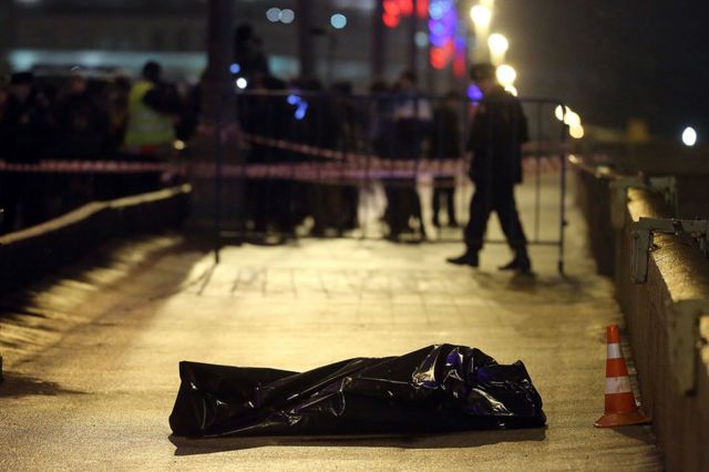 Russian police investigators stand near the body of killed Russian opposition leader and former Deputy Prime Minister Boris Nemtsov, covered by plastic, on Bolshoi Moskvoretsky bridge near St. Basil cathedral on February 28, 2015 in central Moscow, Russia (Photo by Sasha Mordovets/Getty Images)