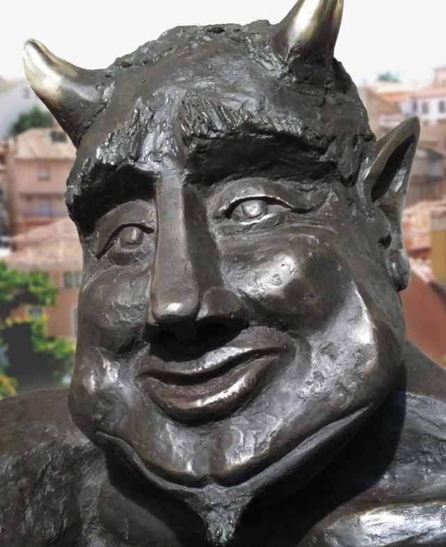 Close-up of the Satan sculpture with smiling face