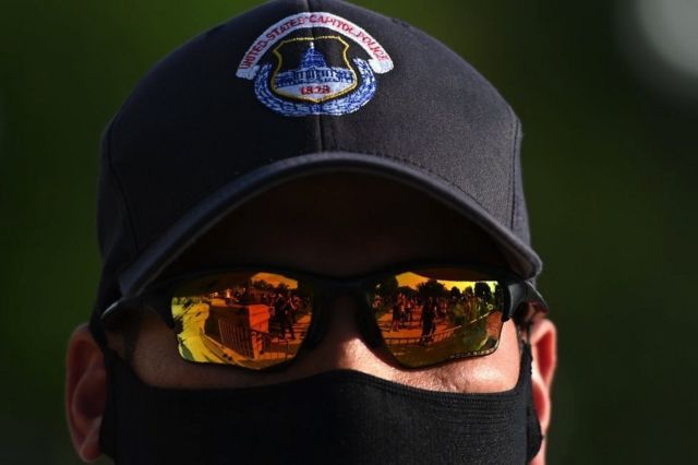 Demonstrators reflections are seen in the glasses of a US Capitol police officer during a protest in front of the United States Capitol in Washington, DC, on June 2, 2020.
