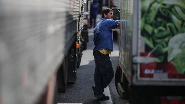 Homem em meio a caminhões parados em greve no Rio de Janeiro