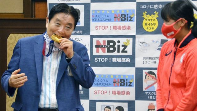 Prefeito Takashi Kawamura morde a medalha de ouro de Miu Goto