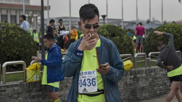 北京マラソンの開始前にたばこを吸うランナー(9月20日)