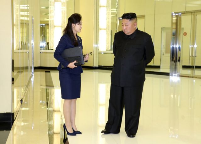 (캡션) 리설주 여사가 김정은 위원장의 서류 가방과 안경으로 보이는 것을 들고 있다