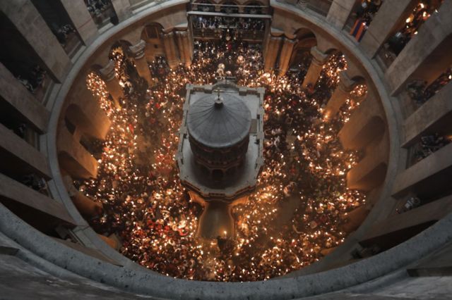 La tumba de Cristo desde los alto y los fieles con velas alrededor durante la Pascua.