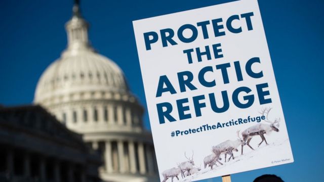 Un manifestant tient un panneau contre le forage dans le refuge arctique lors d'une conférence de presse devant le Capitole américain