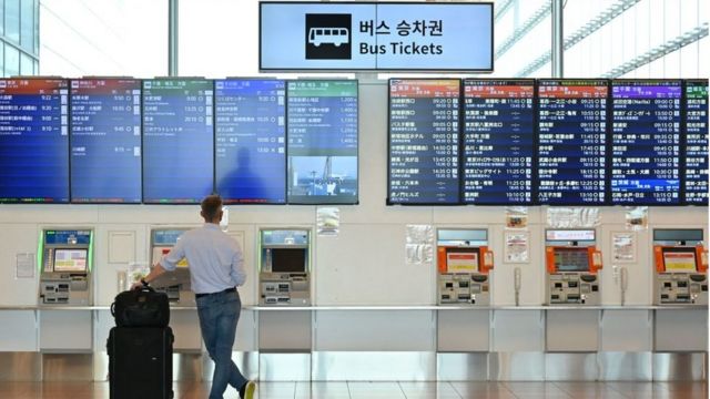 Una persona mira los paneles de salidas y llegadas en el aeropuerto de Tokio.
