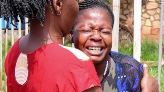 Une femme est assistée alors qu'elle réagit près du lieu d'une explosion à Kampala, en Ouganda, le 16 novembre 2021.