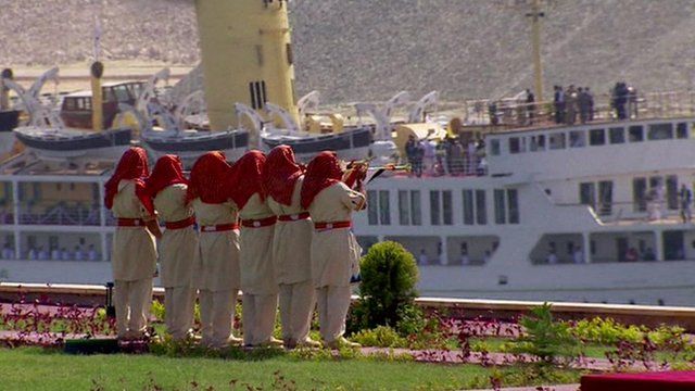 Trumpeters playing as a ship sails past