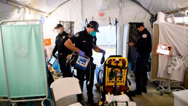 Sala de emergência improvisada dentro de uma tenda em hospital de Los Angeles; paramédicos circulam pelo local