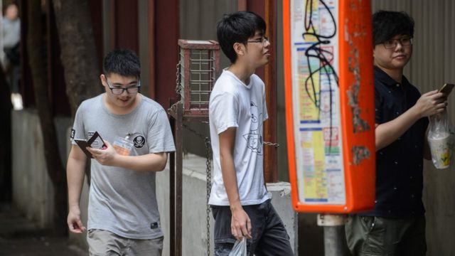 Jovens jogam Pokémon Go em Hong Kong