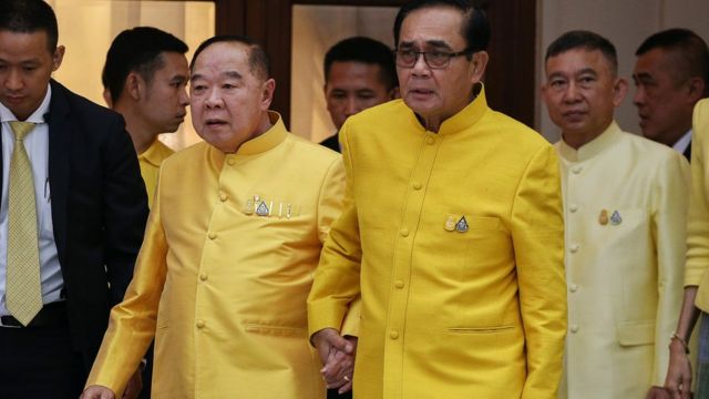 Prime Minister Prayuth Chan-ocha holds hands with Deputy Prime Minister and Defence Minister Prawit Wongsuwan