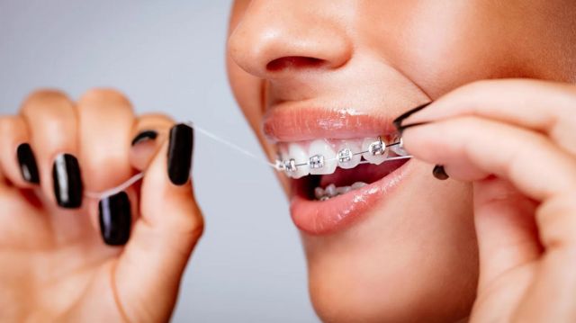 Gros Plan D'un Dentier Avec Des Dents Artificielles Blanches Et Une Brosse  à Dents Rouge