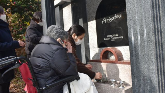Familiares depositam a urna com as cinzas de Vitor Higa durante cerimônia católica realizada dia 27 de novembro, em Tóquio