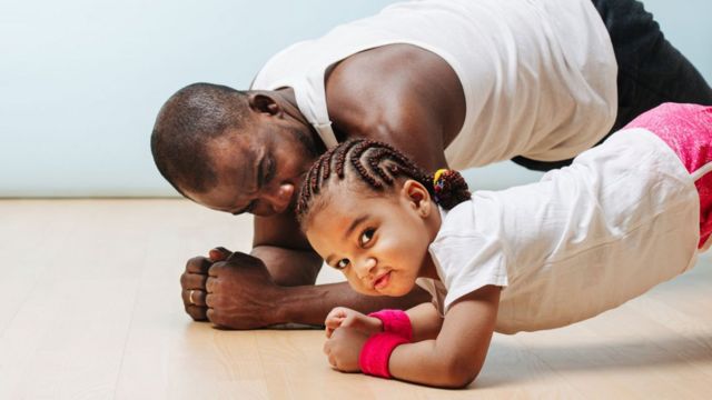 Un padre practica ejercicios con su hija