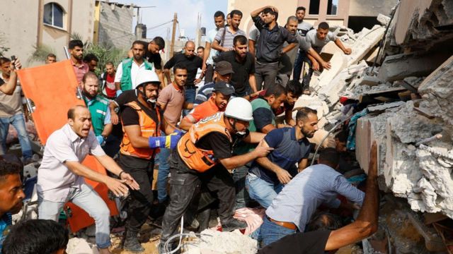 Palestinos procuram vítimas sob os escombros de uma casa destruída em ataques israelenses em Khan Younis, no sul da Faixa de Gaza