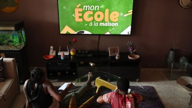 Jovens da Costa do Marfim tendo aulas pela televisão, que está sendo usada por redes estaduais e municipais do Brasil para chegar aos alunos