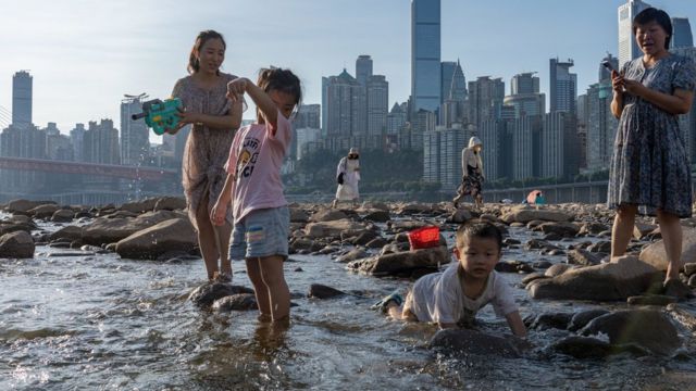Men, women and children of the Jialing River in Chongqing take advantage of the sharp drop in the water level to walk into the riverbed to play in the water to cool down (21/8/2022)