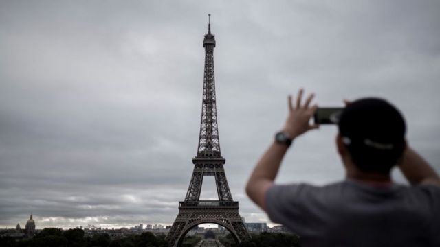 Un hombre toma una foto a la Torre Eiffel